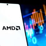 Celular com logotipo da AMD na tela e linhas de ações financeiras ao fundo