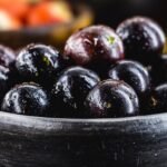 Jaboticaba or jabuticaba, Brazilian and South American fruit, in a clay pot. with tropical fruits in the background.